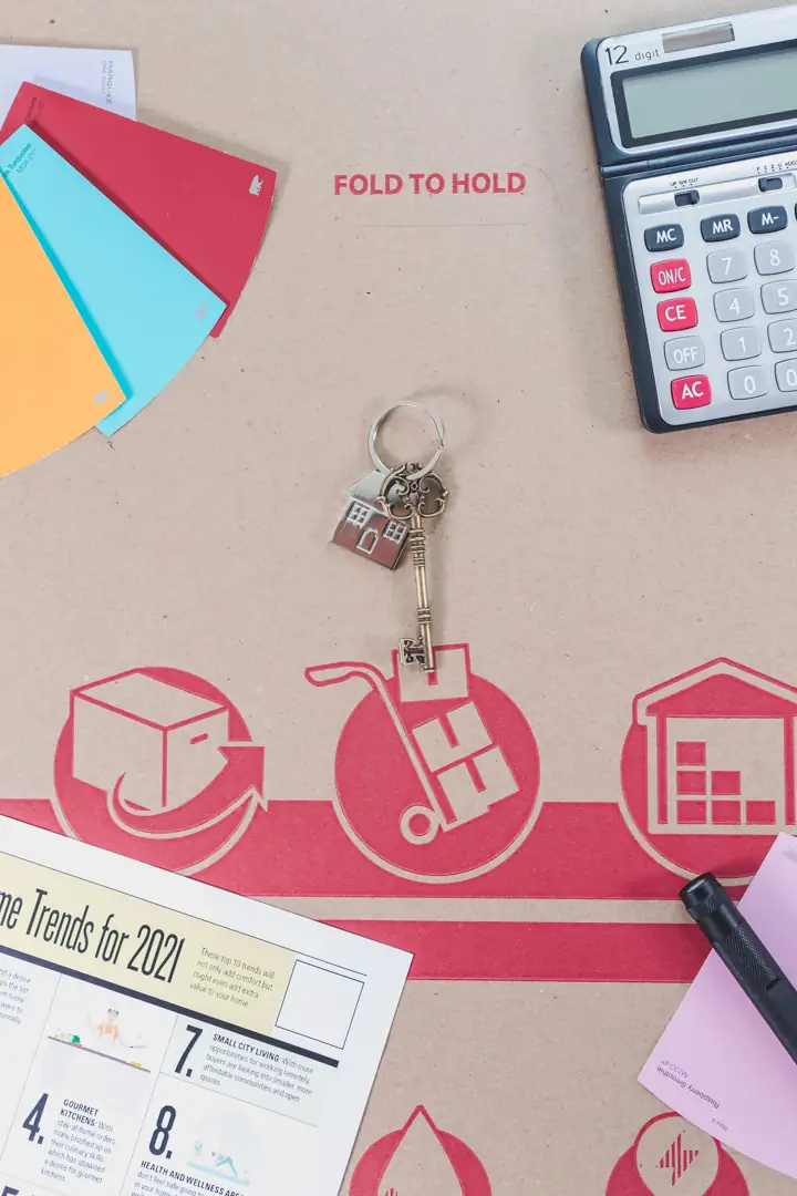 House keys, a calculator and paperwork laid out on a table